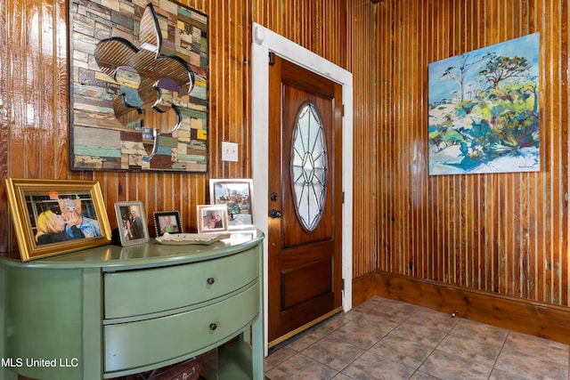 entryway featuring tile patterned flooring and wooden walls