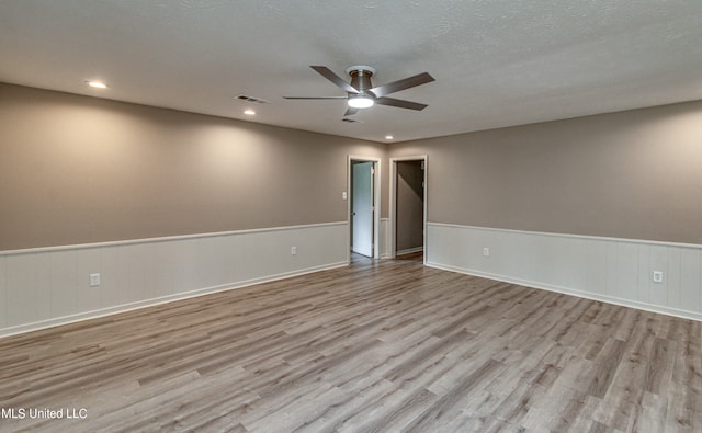 spare room with light hardwood / wood-style flooring, a textured ceiling, and ceiling fan