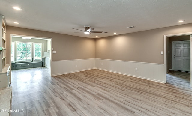 spare room featuring light hardwood / wood-style flooring, a textured ceiling, and ceiling fan