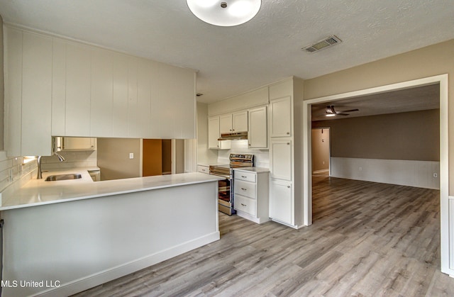 kitchen featuring sink, electric range, kitchen peninsula, white cabinetry, and light hardwood / wood-style flooring