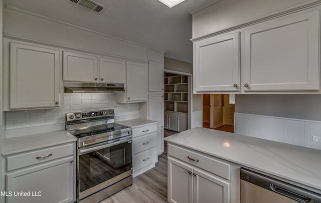 kitchen featuring backsplash, white cabinetry, stainless steel appliances, and light hardwood / wood-style floors