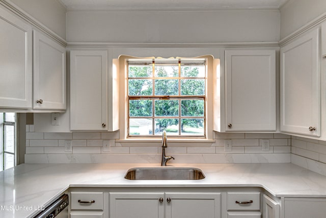 kitchen featuring white cabinetry, dishwasher, sink, and tasteful backsplash