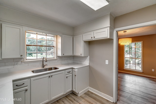 kitchen featuring sink, white cabinetry, and tasteful backsplash