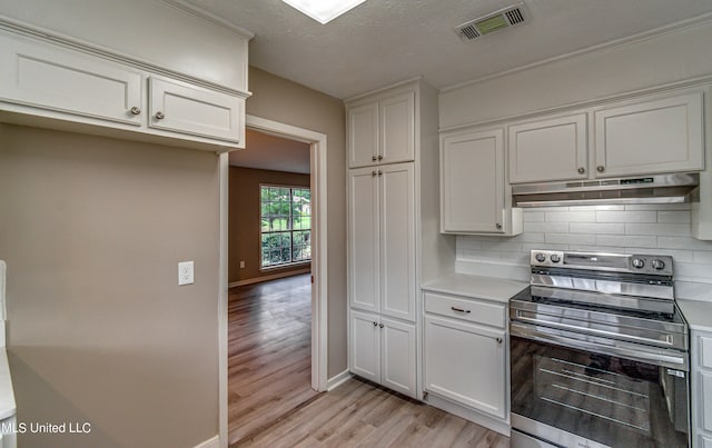 kitchen with decorative backsplash, stainless steel range with electric cooktop, white cabinetry, a textured ceiling, and light wood-type flooring