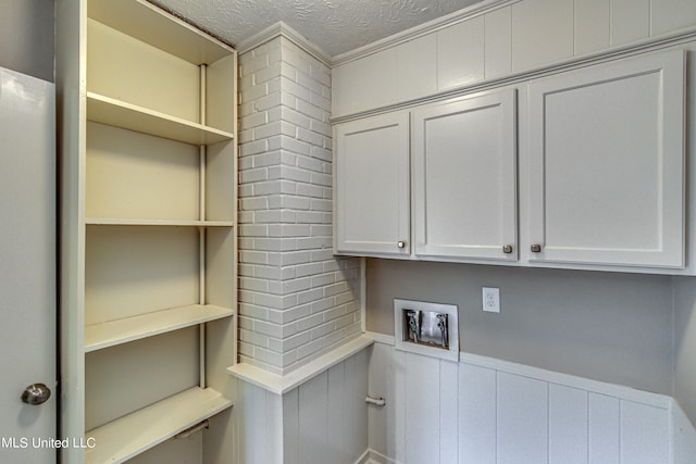 washroom featuring ornamental molding, hookup for an electric dryer, and a textured ceiling