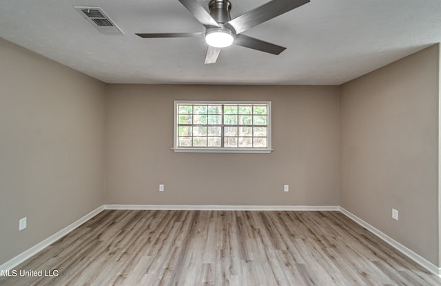 unfurnished room with a textured ceiling, light wood-type flooring, and ceiling fan