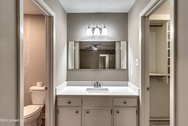 bathroom with vanity, toilet, a textured ceiling, and hardwood / wood-style floors