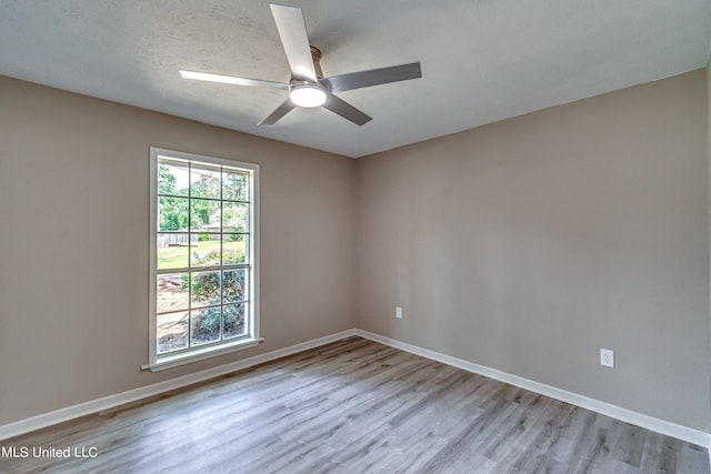 spare room with ceiling fan, a textured ceiling, and light hardwood / wood-style flooring