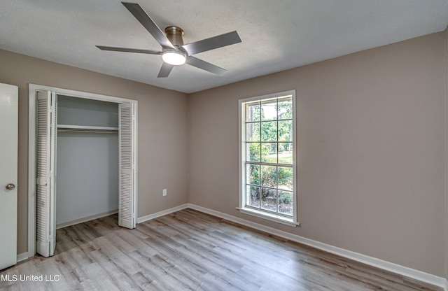 unfurnished bedroom featuring light hardwood / wood-style flooring, a closet, and ceiling fan