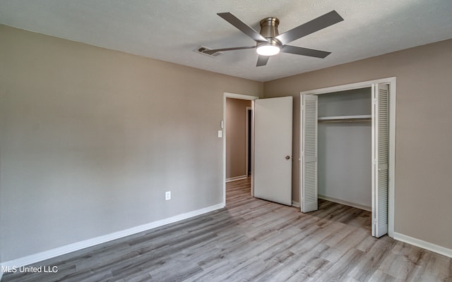 unfurnished bedroom featuring a closet, ceiling fan, a textured ceiling, and light wood-type flooring