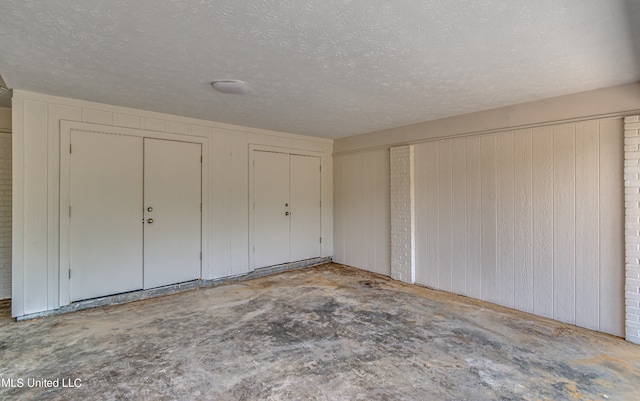 unfurnished bedroom with two closets and a textured ceiling