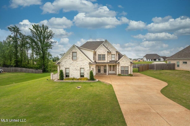 view of front of home featuring fence, a front lawn, brick siding, stone siding, and concrete driveway