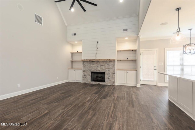 unfurnished living room with crown molding, baseboards, dark wood-style flooring, and visible vents