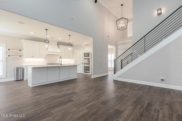unfurnished living room featuring a healthy amount of sunlight, baseboards, and dark wood finished floors