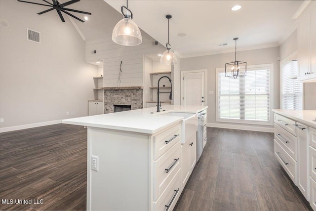 kitchen with a sink, dark wood finished floors, baseboards, open floor plan, and visible vents