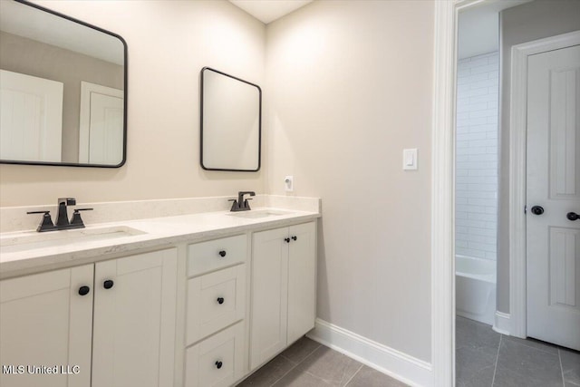 bathroom featuring tile patterned flooring, a sink, baseboards, and double vanity