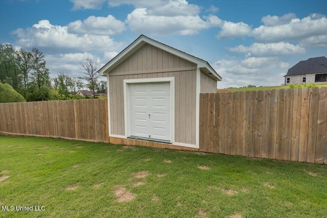 garage featuring fence and a shed