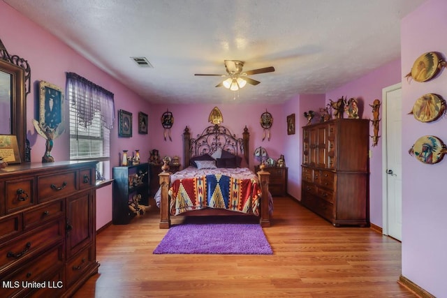 bedroom featuring light wood-style floors, ceiling fan, and visible vents