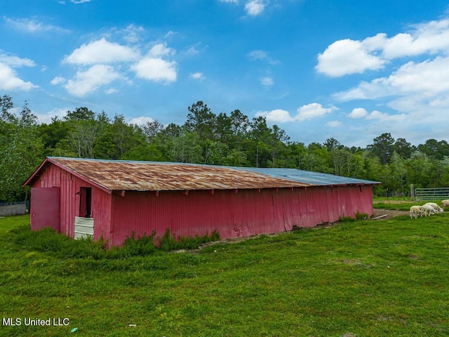 view of pole building with a yard and a forest view