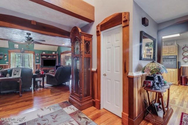 corridor with beam ceiling and light wood-style flooring