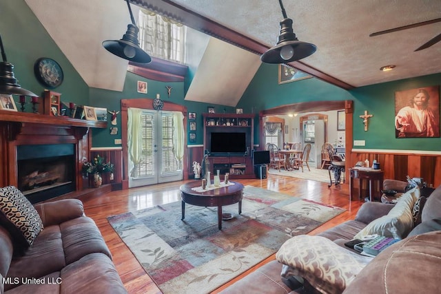 living area featuring ceiling fan, wainscoting, and plenty of natural light