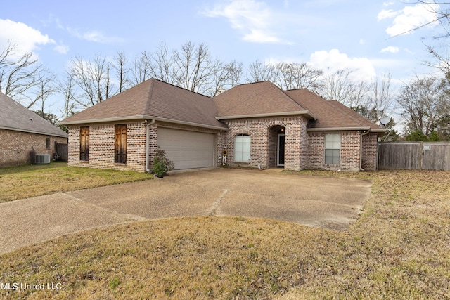 view of front of property with central AC, a front lawn, and a garage