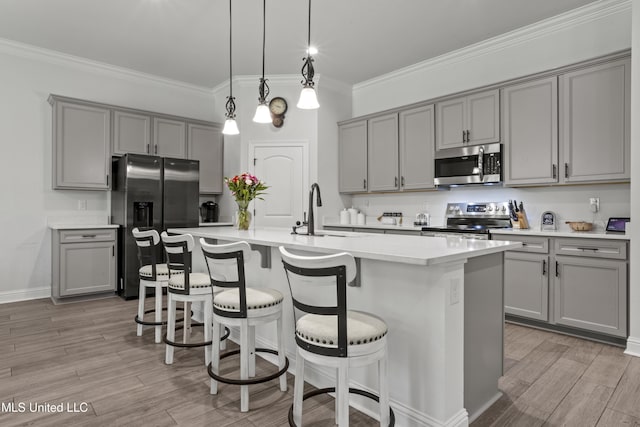 9363 Taylor Pl, Ocean Springs, MS 39564 - kitchen featuring gray cabinetry, appliances with stainless steel finishes, a sink, and crown molding