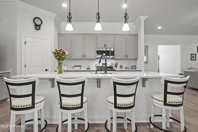 9363 Taylor Pl, Ocean Springs, MS 39564 - kitchen with stainless steel appliances, gray cabinetry, crown molding, light countertops, and recessed lighting