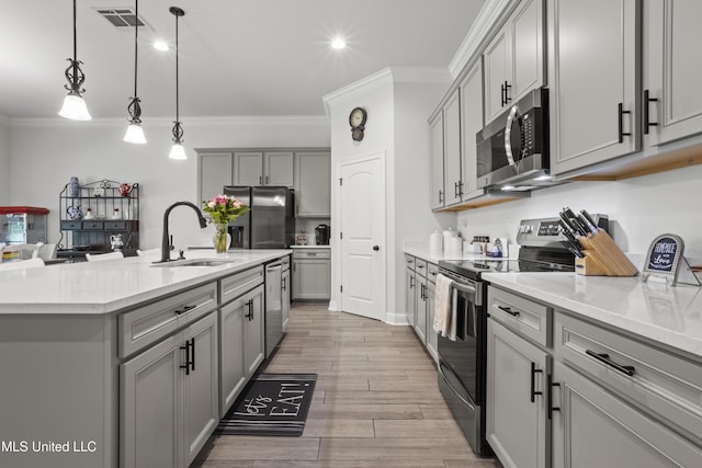 9363 Taylor Pl, Ocean Springs, MS 39564 - kitchen with stainless steel appliances, gray cabinets, a sink, crown molding, and recessed lighting