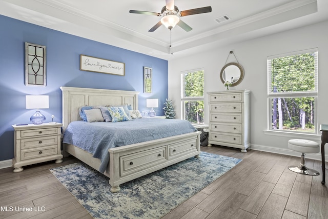 9363 Taylor Pl, Ocean Springs, MS 39564 - bedroom featuring a tray ceiling, wood finished floors, crown molding, baseboards, and ceiling fan