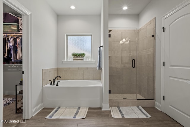 9363 Taylor Pl, Ocean Springs, MS 39564 - bathroom featuring wood finished floors, a shower stall, a garden tub, a walk in closet, and recessed lighting