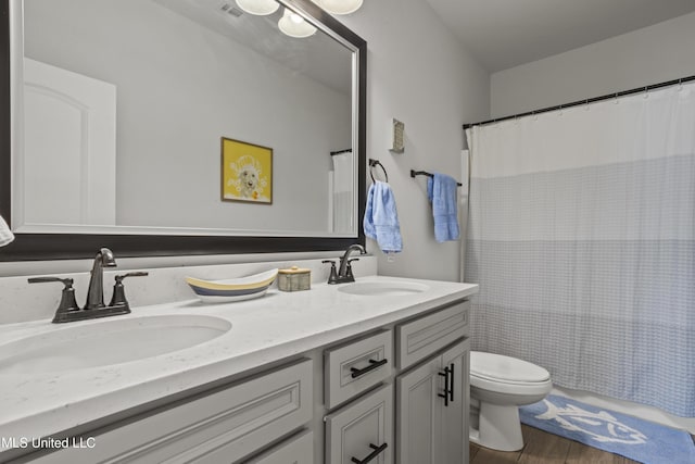9363 Taylor Pl, Ocean Springs, MS 39564 - bathroom with toilet, double vanity, wood finished floors, and a shower with curtain