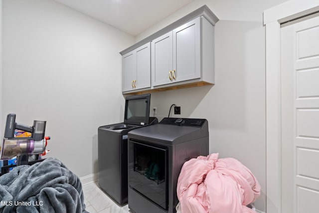 6731 Bobwhite Cir, Southaven, MS 38672 - laundry area featuring separate washer and dryer, cabinet space, light marble finish flooring, and baseboards