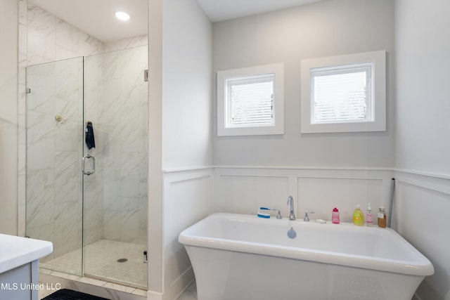 6731 Bobwhite Cir, Southaven, MS 38672 - full bathroom featuring a freestanding tub, a shower stall, a decorative wall, wainscoting, and marble look tile flooring