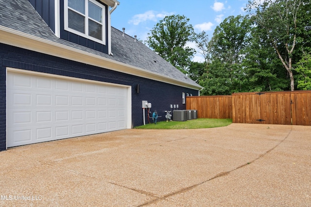 6731 Bobwhite Cir, Southaven, MS 38672 - view of side of property with concrete driveway, roof with shingles, brick siding, and central AC