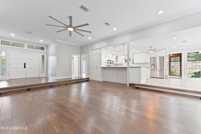 unfurnished living room with crown molding, wood-type flooring, and ceiling fan