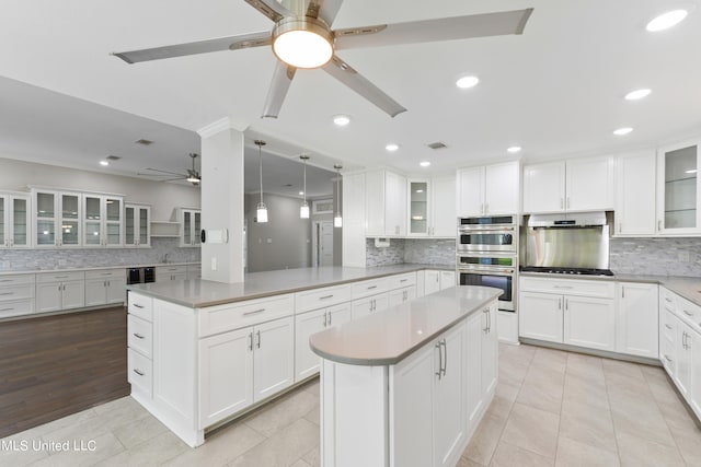 kitchen with a kitchen island, white cabinetry, kitchen peninsula, and stainless steel appliances