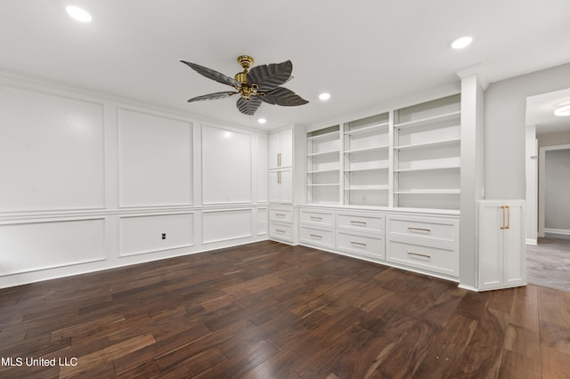 spare room featuring ceiling fan, built in features, and dark hardwood / wood-style flooring