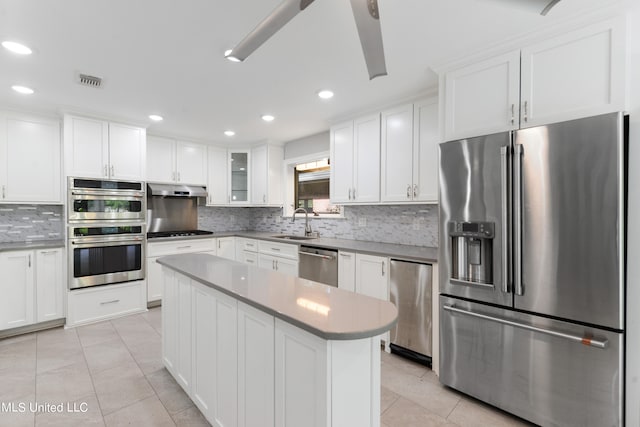 kitchen featuring backsplash, sink, appliances with stainless steel finishes, and white cabinetry