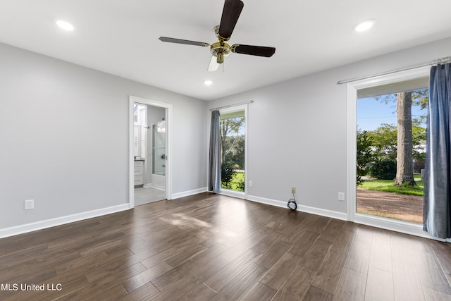 spare room with ceiling fan, a wealth of natural light, and dark hardwood / wood-style floors