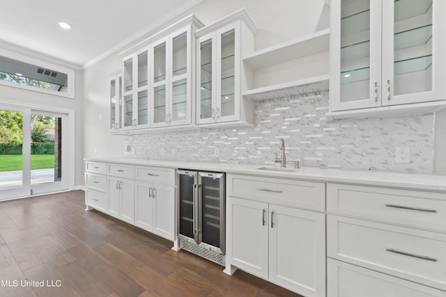 kitchen with ornamental molding, white cabinets, dark hardwood / wood-style floors, and beverage cooler