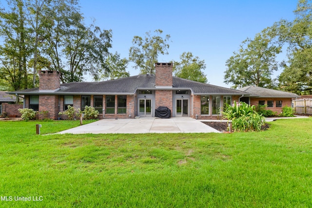 back of property featuring a patio and a lawn