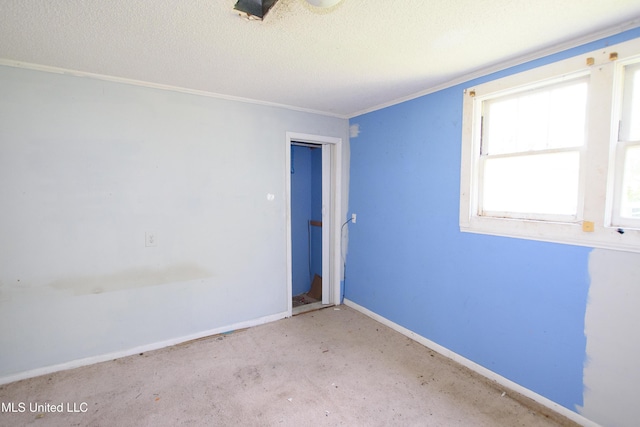 empty room with a textured ceiling and baseboards
