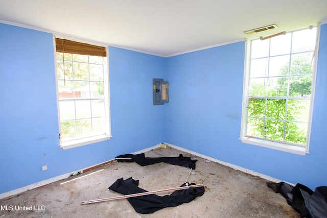 spare room with baseboards, electric panel, and crown molding