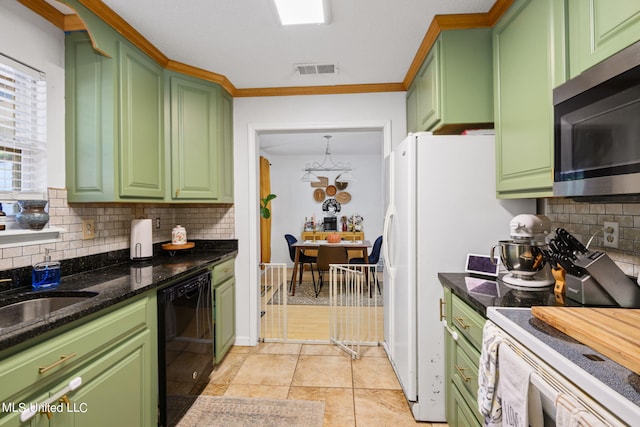 kitchen with green cabinetry, stainless steel appliances, and tasteful backsplash