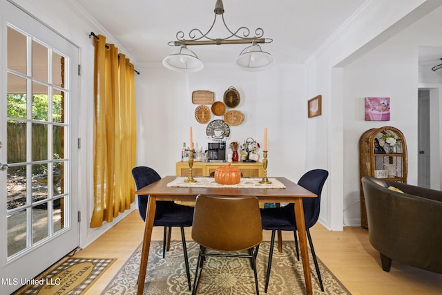 dining area featuring light hardwood / wood-style floors and ornamental molding