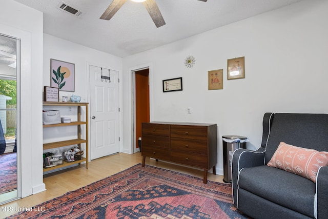 sitting room with hardwood / wood-style flooring and ceiling fan