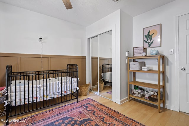 bedroom featuring a closet, ceiling fan, hardwood / wood-style flooring, and a textured ceiling