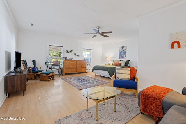 bedroom with light hardwood / wood-style flooring, ceiling fan, and crown molding