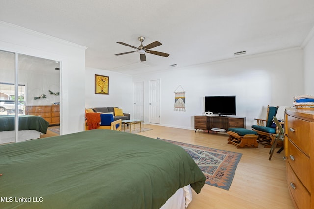 bedroom with ceiling fan, crown molding, and light wood-type flooring